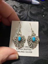The sterling silver Thunderbird with a small stone of turquoise in each earrings